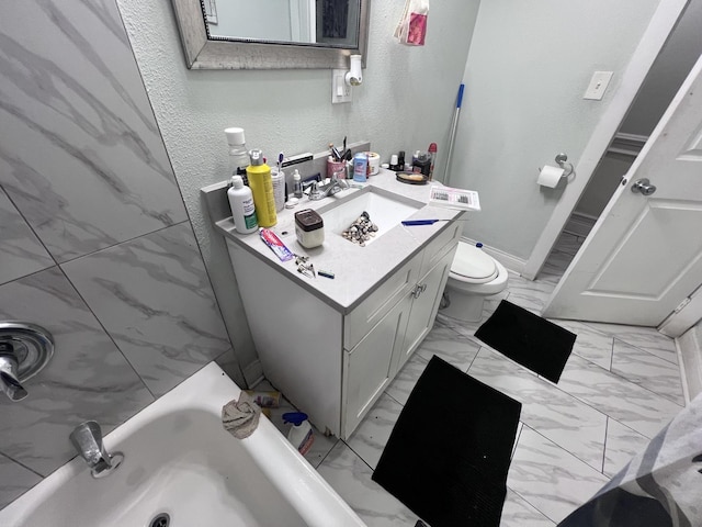 full bathroom featuring a bath, vanity, baseboards, toilet, and marble finish floor