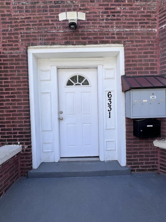 doorway to property featuring brick siding