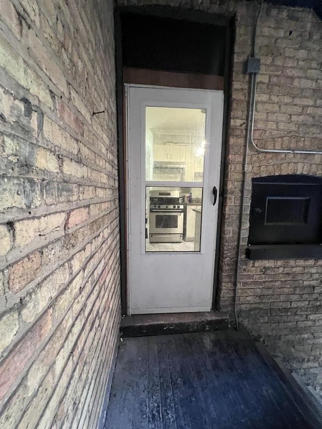 doorway to property with brick siding