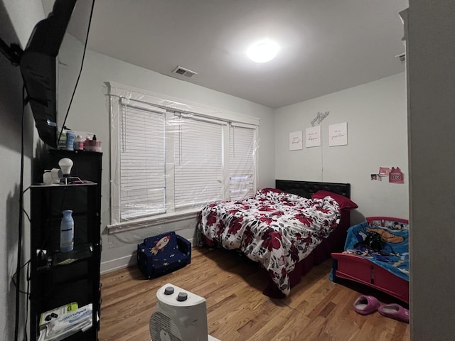 bedroom featuring wood finished floors and visible vents