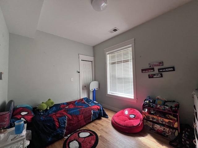 bedroom with wood finished floors and visible vents