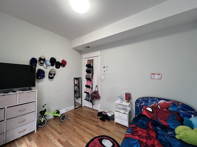 bedroom featuring visible vents, baseboards, and wood finished floors