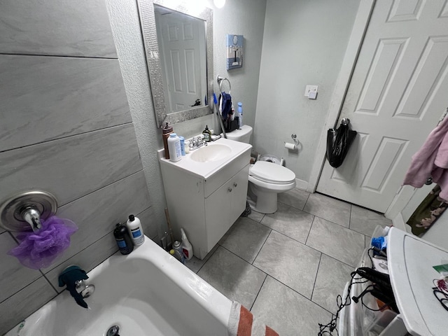 bathroom with toilet, tile patterned floors, a bathtub, and vanity