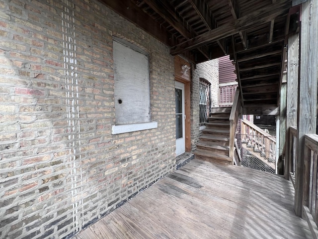 exterior space with brick wall and wood finished floors