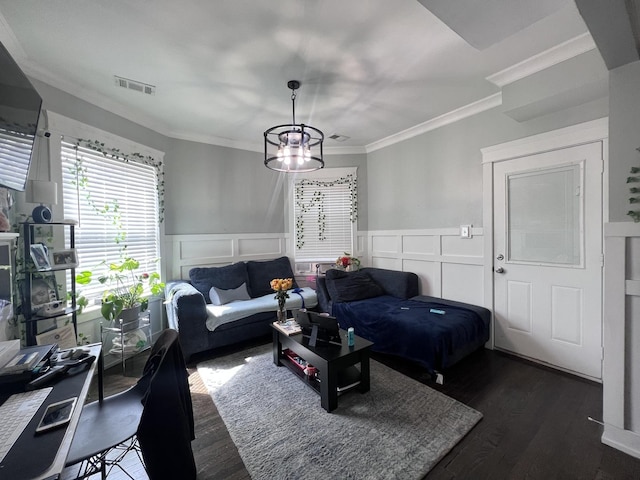 living room with visible vents, crown molding, a wainscoted wall, dark wood-style floors, and a decorative wall