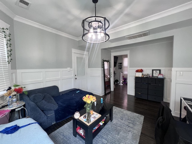living room with ornamental molding, wainscoting, dark wood-style floors, and visible vents