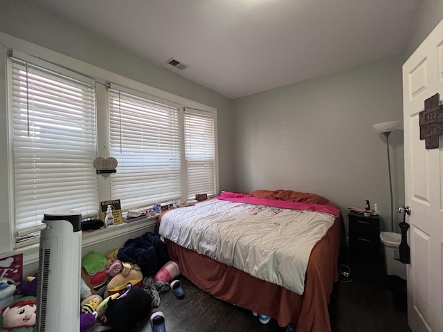 bedroom with visible vents and wood finished floors