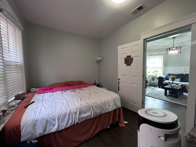 bedroom with visible vents and dark wood finished floors