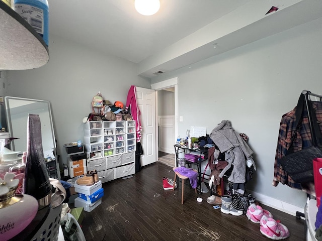 bedroom featuring baseboards, wood finished floors, and visible vents