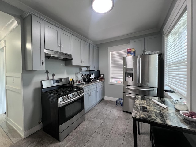 kitchen featuring crown molding, under cabinet range hood, a wealth of natural light, and stainless steel appliances
