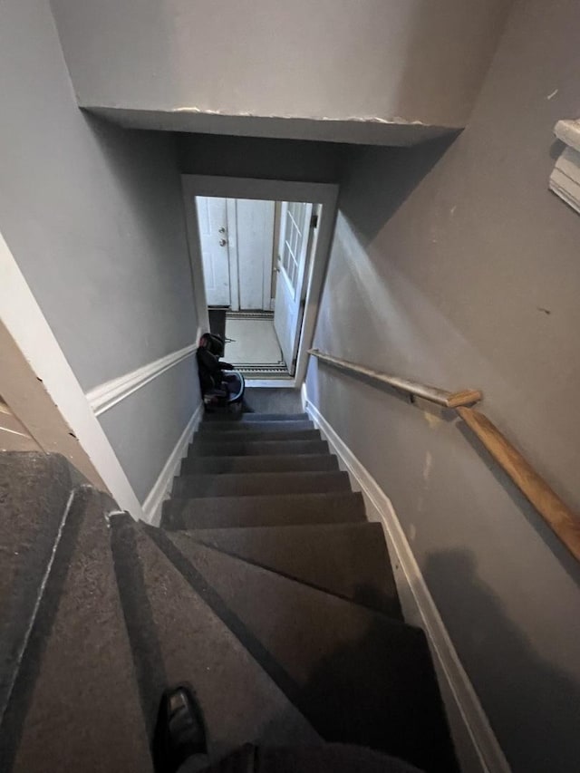 stairway with baseboards and carpet