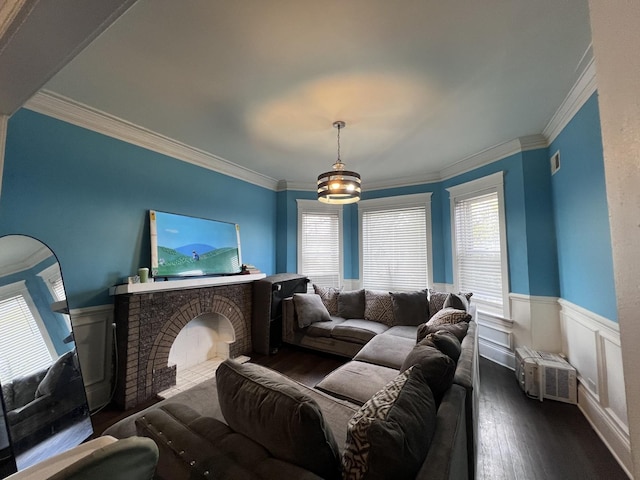 living area with a wainscoted wall, ornamental molding, and dark wood-style floors