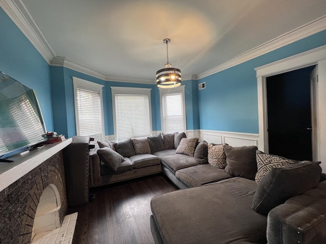 living room with visible vents, crown molding, a wainscoted wall, and hardwood / wood-style flooring