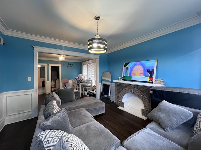 living room featuring crown molding, wainscoting, and wood finished floors