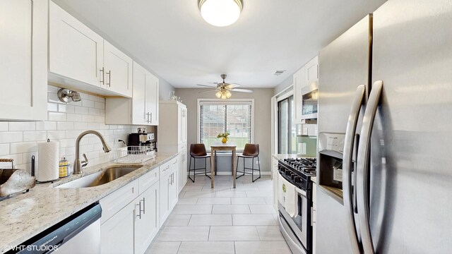1670 W Partridge Ln Unit 5, Arlington Heights, IL 60004 - kitchen featuring decorative backsplash, light stone counters, a sink, appliances with stainless steel finishes, and light tile patterned floors