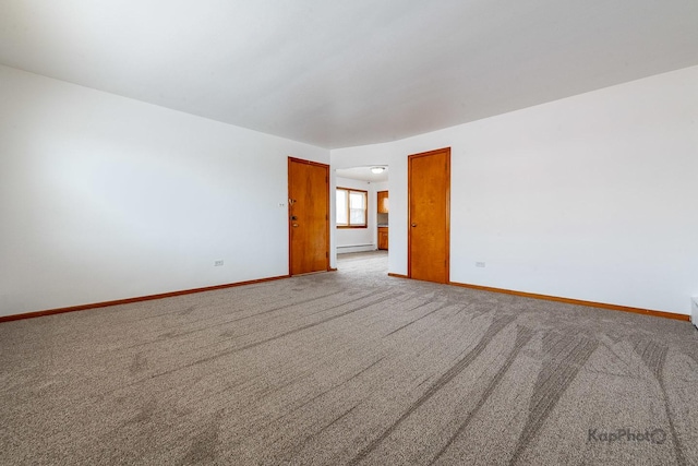 spare room with baseboards, carpet flooring, and a baseboard radiator
