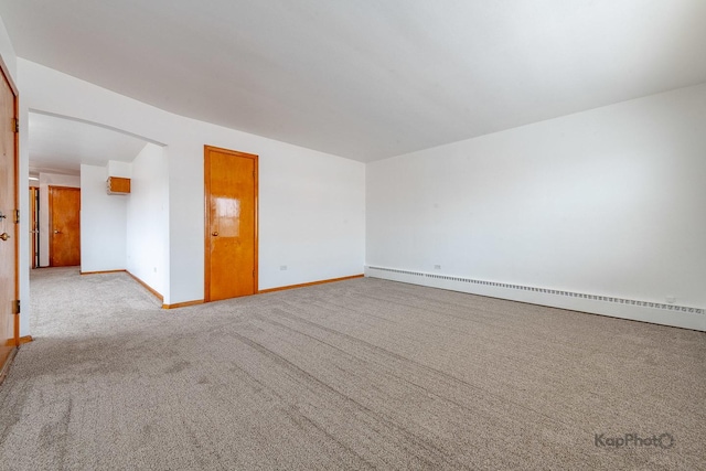 spare room featuring carpet floors, baseboards, and baseboard heating