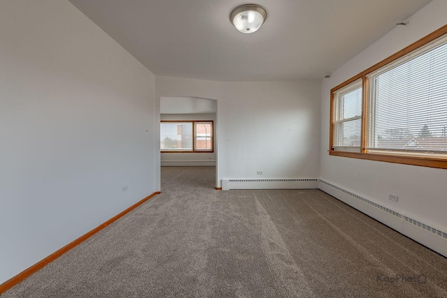 carpeted empty room featuring baseboards and a baseboard heating unit