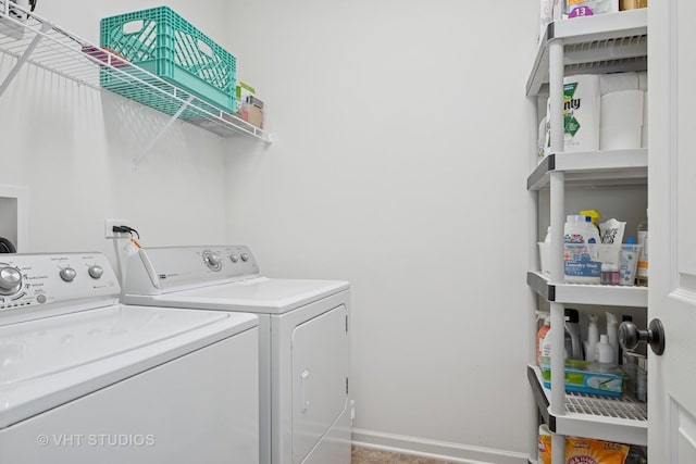 clothes washing area with laundry area, washing machine and dryer, and baseboards