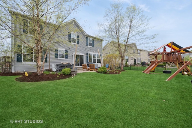 rear view of house with a lawn, fence, a patio area, and a playground