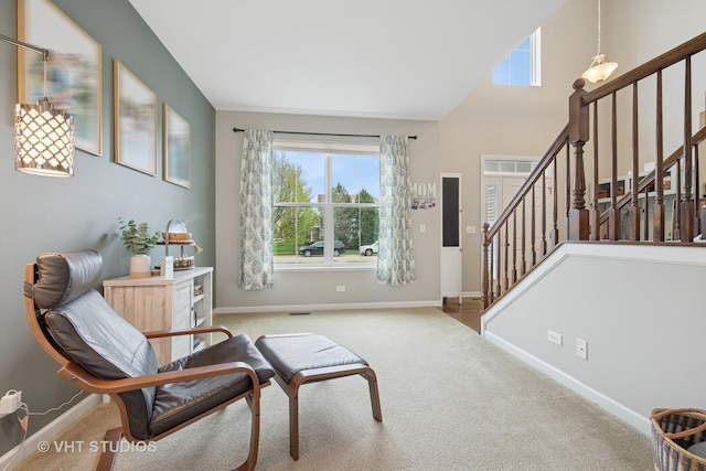 living area featuring baseboards, carpet, and stairs