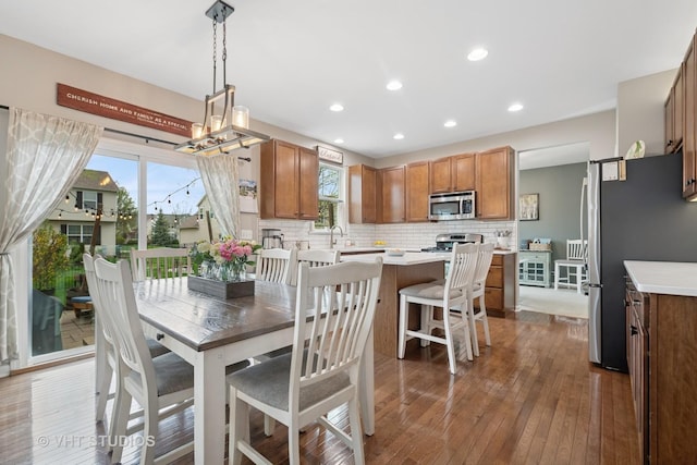 dining area featuring recessed lighting, a notable chandelier, and hardwood / wood-style flooring