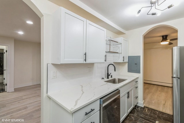 kitchen featuring baseboard heating, arched walkways, electric panel, a sink, and stainless steel appliances