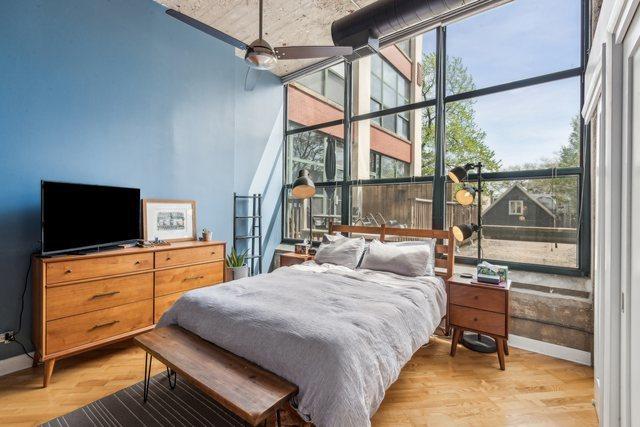 bedroom with baseboards, floor to ceiling windows, and light wood-type flooring