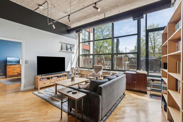living room with baseboards, rail lighting, floor to ceiling windows, and light wood-style flooring