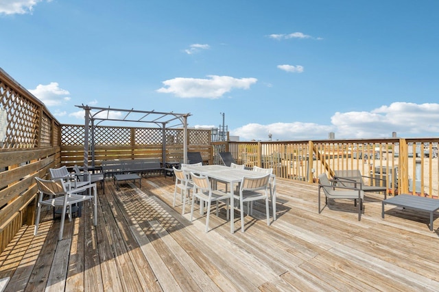 wooden deck featuring a pergola and outdoor dining space