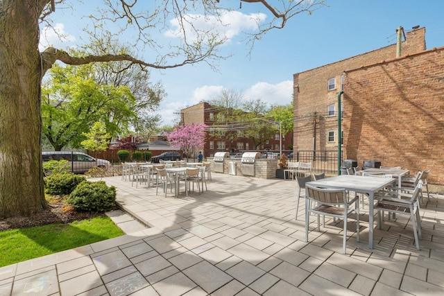 view of patio / terrace featuring exterior kitchen, fence, and outdoor dining space