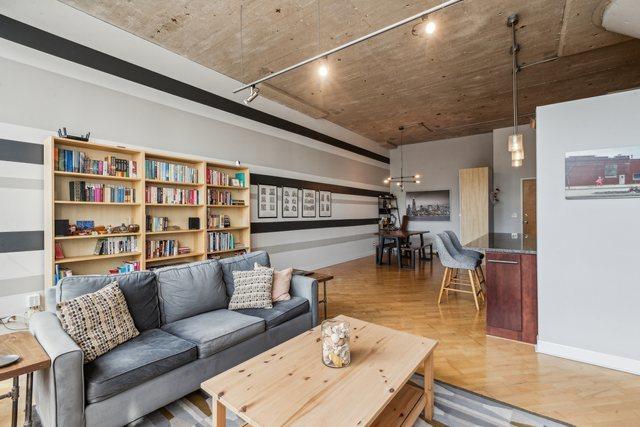 living room featuring baseboards, rail lighting, and wood finished floors