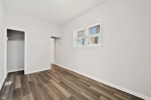 unfurnished bedroom featuring baseboards, a closet, and dark wood-style flooring