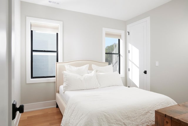 bedroom with baseboards, visible vents, and light wood-style flooring
