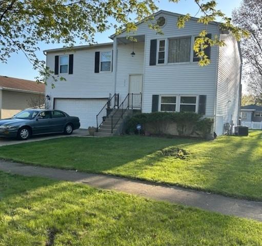 2410 Parklake Dr, Morris, IL 60450 - bi-level home with an attached garage, central air condition unit, driveway, and a front yard