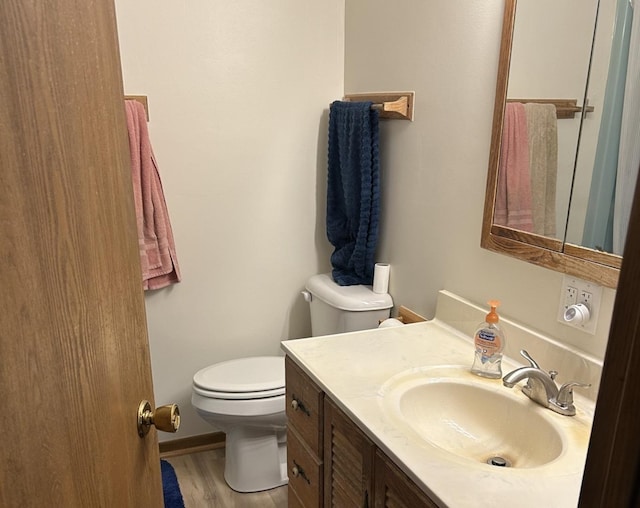 bathroom featuring vanity, toilet, and wood finished floors