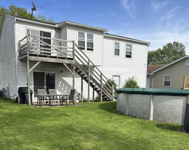 rear view of property featuring a yard, central AC, and stairway