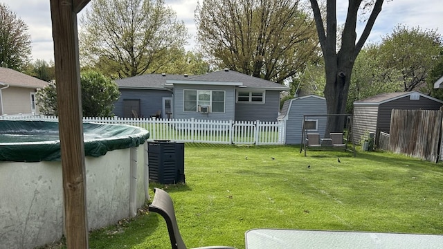 view of yard with a storage unit, a fenced in pool, cooling unit, an outdoor structure, and fence private yard
