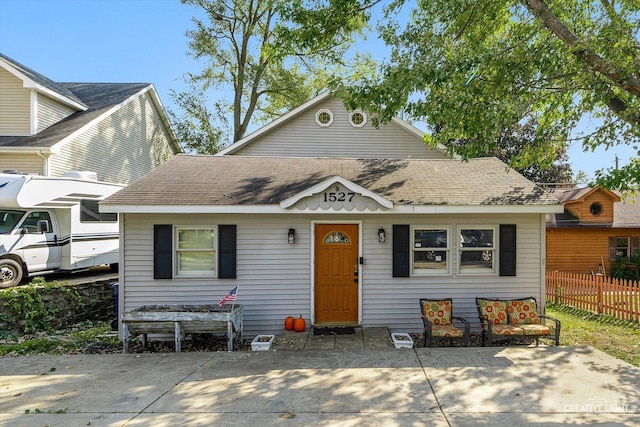 bungalow-style home with fence