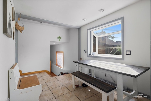 interior space with baseboards and light tile patterned floors