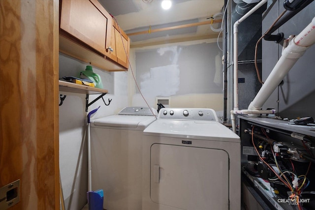 clothes washing area with heating unit, cabinet space, and independent washer and dryer
