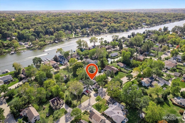 aerial view with a residential view, a water view, and a view of trees