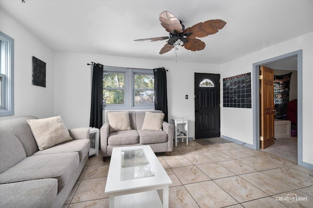 living area with baseboards and a ceiling fan