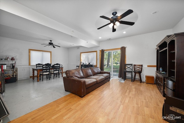 living area featuring light wood-style floors, a ceiling fan, and recessed lighting