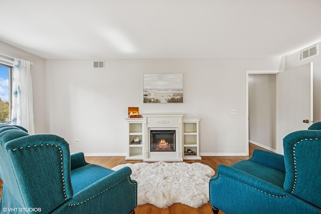 28139 W Okelly Dr, Ingleside, IL 60041 - living area with baseboards, visible vents, a glass covered fireplace, and wood finished floors