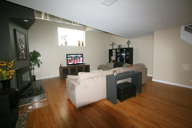 living area featuring recessed lighting, baseboards, and wood finished floors