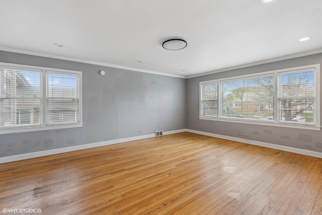 spare room with light wood finished floors, recessed lighting, crown molding, visible vents, and baseboards