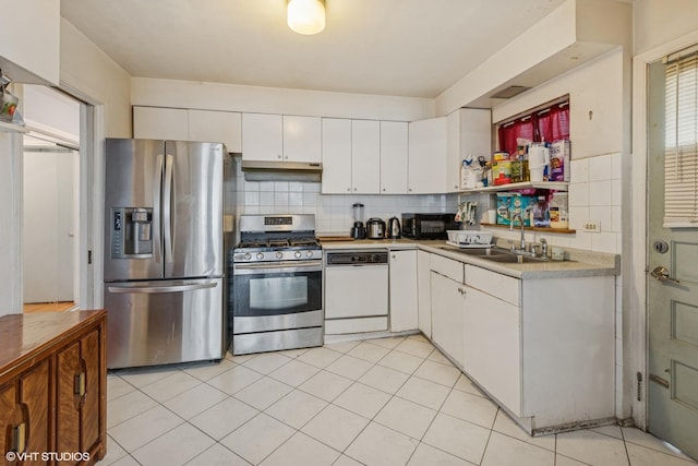 kitchen with light tile patterned floors, stainless steel appliances, light countertops, a sink, and white cabinetry