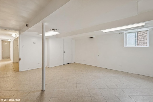 basement featuring light tile patterned floors and baseboards