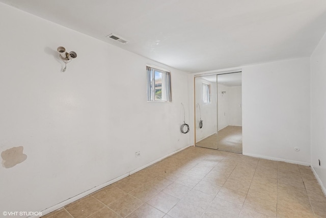 spare room featuring visible vents and baseboards